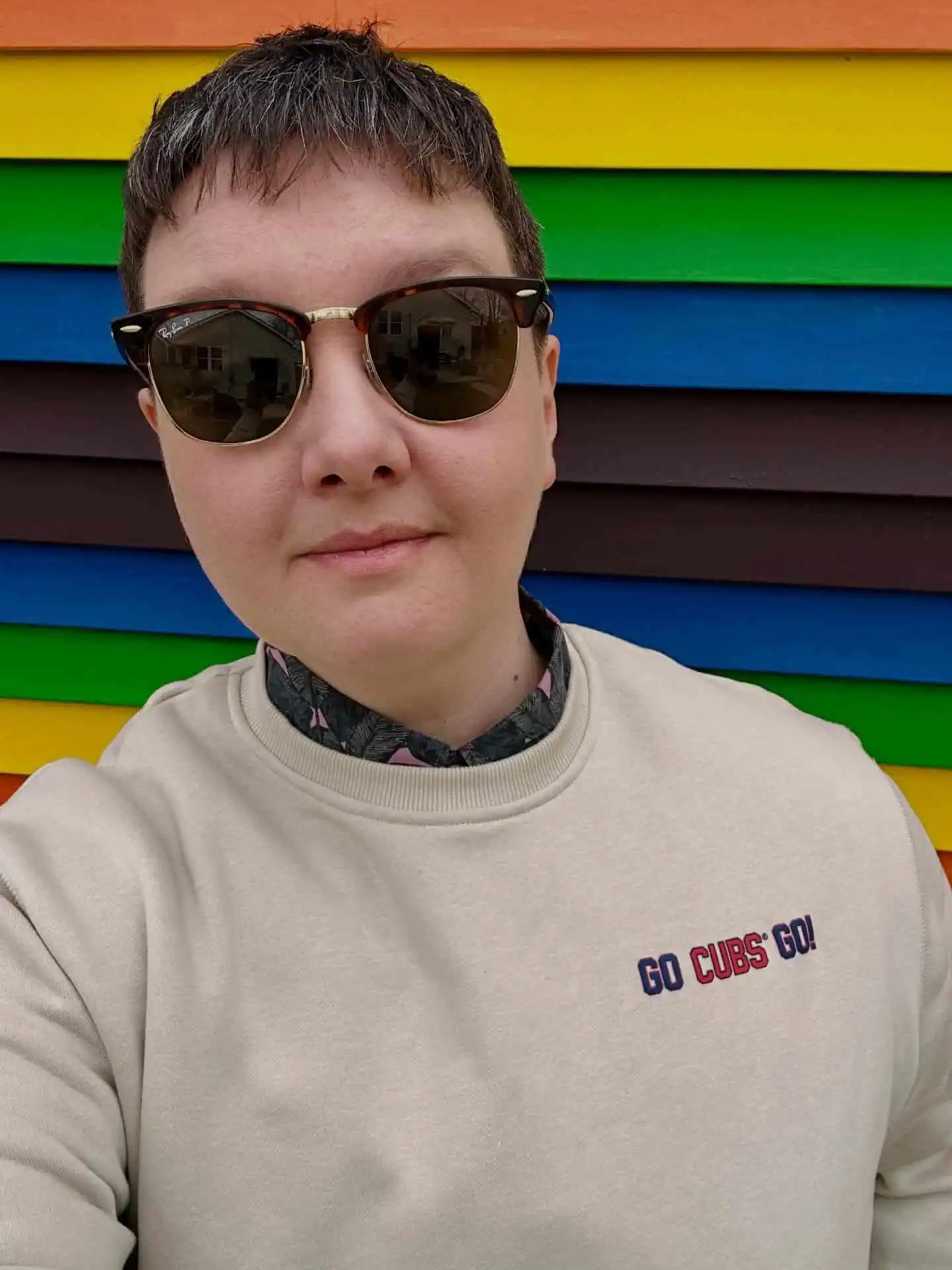 658427258_18576309685035943_307187764511227764_n A person with glasses and a colorful necklace looks directly at the camera, wearing a light-colored shirt indoors.